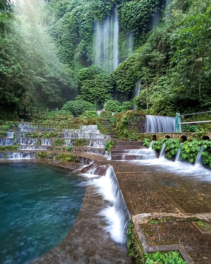 Pemandangan Air Terjun Benang Kelambu dengan aliran airnya yang menyerupai tirai benang di Lombok. Wisata alam, air terjun unik, Nusa Tenggara Barat