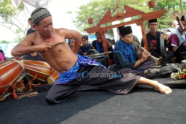 Seorang jawara Debus sedang menusuk perutnya dengan tombak dalam pertunjukan Debus di Banten. Seni bela diri, atraksi ekstrem