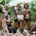 Pemandangan Tiang Bis (Bis Poles), ukiran kayu raksasa Suku Asmat, dalam sebuah upacara adat. Seni ukir, budaya Papua."