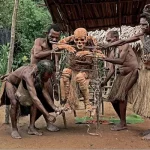 Potret seorang pria Suku Korowai dengan busur dan anak panah, bersiap untuk berburu. Gaya hidup tradisional, kearifan lokal