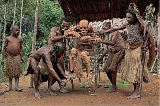 Potret seorang pria Suku Korowai dengan busur dan anak panah, bersiap untuk berburu. Gaya hidup tradisional, kearifan lokal